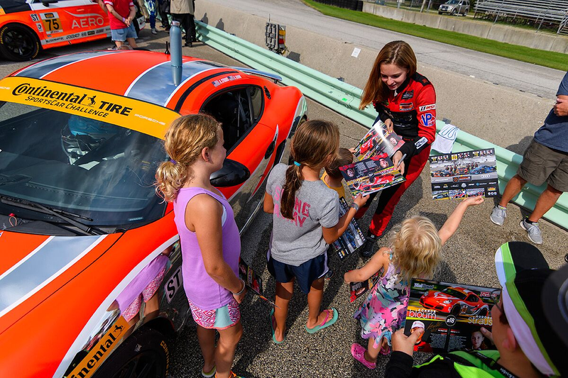 Straus signing autographs for a group of people, mostly young girls. Photo credit: Wes Duenkel, used with permission